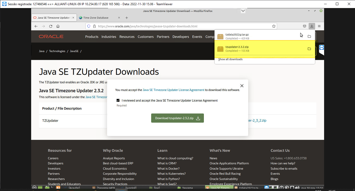 Diálogo de licença do Oracle com checkbox "I reviewed and accept the Java SE Timezone Updater License Agreement" marcado e botão "Download tzupdater-2.3.2.zip" em destaque; painel de downloads do Firefox mostra tzupdater-2.3.2.zip concluído