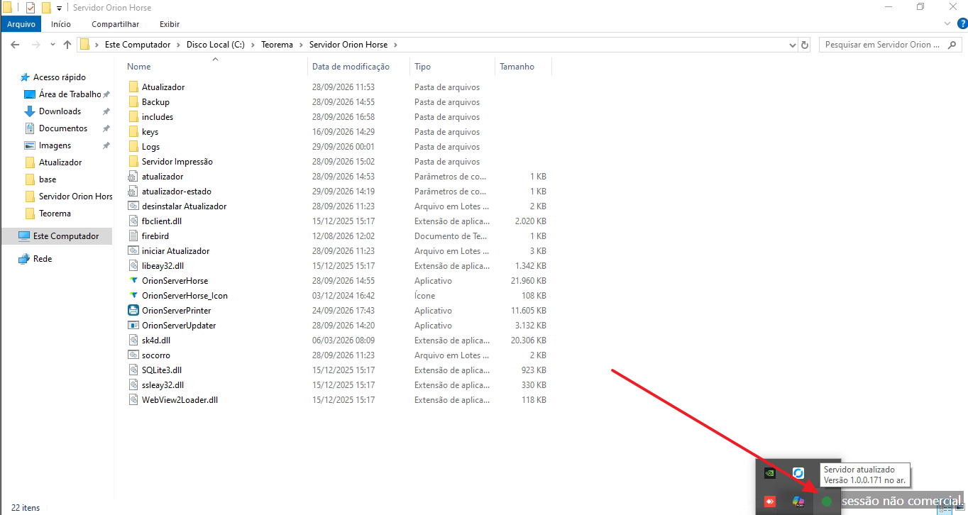 Barra de tarefas do Windows com seta apontando para o ícone do Atualizador na área de notificação